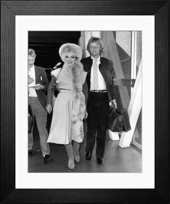 Framed Print : Joan Collins British Actress at Heathrow Airport with boyfriend Peter Holm in October