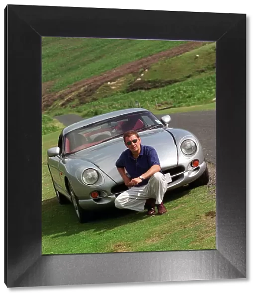John Clelland sitting in front of a silver grey TVR Cerbera car August 1997