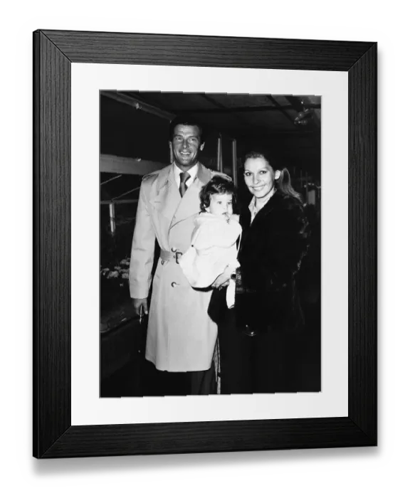 Framed Print : Roger Moore Actor Films James Bond with family leaving Heathrow Airport