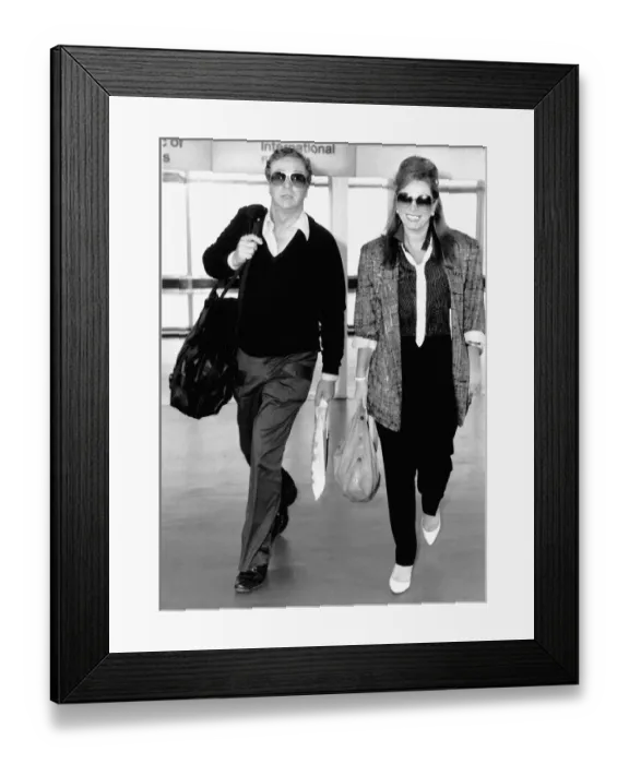 Framed Print : Jackie Collins Actress leaving heathrow airport on the same flight as Michael Caine