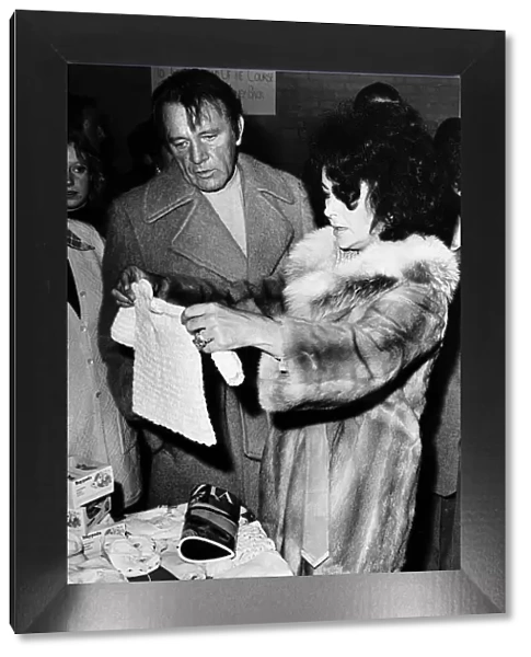 Richard Burton actor and Elizabeth Taylor who recently remarried buying a baby suit