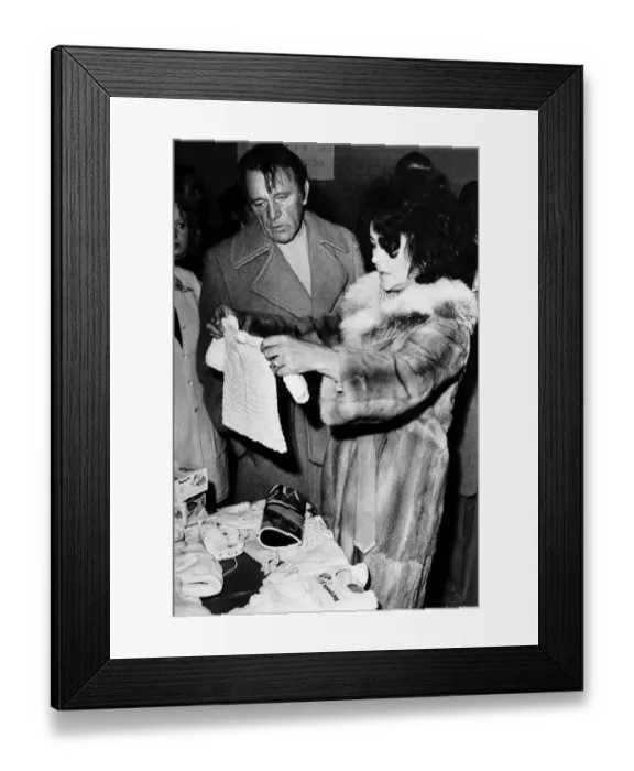 Framed Print : Richard Burton actor and Elizabeth Taylor who recently remarried buying a baby suit Framed Print : Richard Burton actor and Elizabeth Taylor who recently remarried buying a baby suit