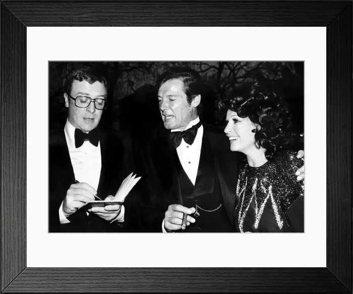 Framed Print : Michael Caine and Roger Moore - April 1976 Michael Caine actor attends