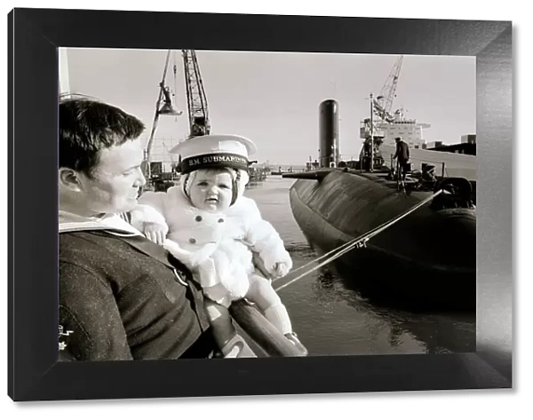 One of the ratings of the new submarine HMS Conqueror shows off his new ship to his son