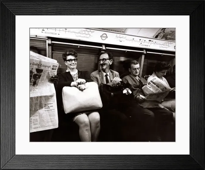Framed Print : A man smoking a pipe pulls a funny face at his traveling companion. September 1969 Framed Print : A man smoking a pipe pulls a funny face at his traveling companion. September 1969