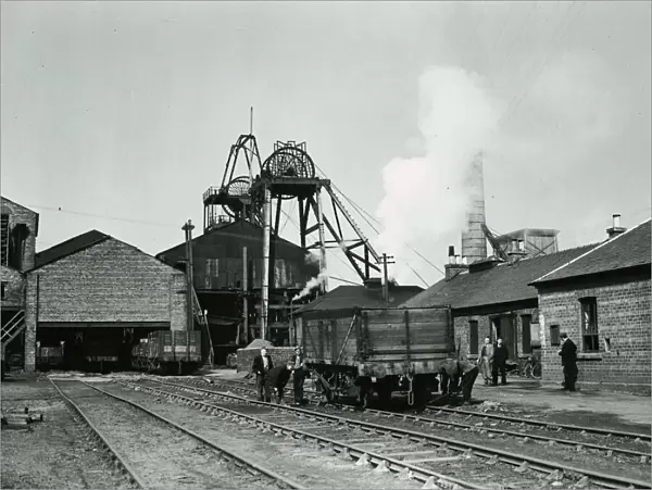 Worklers pulling along a wagon carrying coal at Priory Colliery in Blantyre