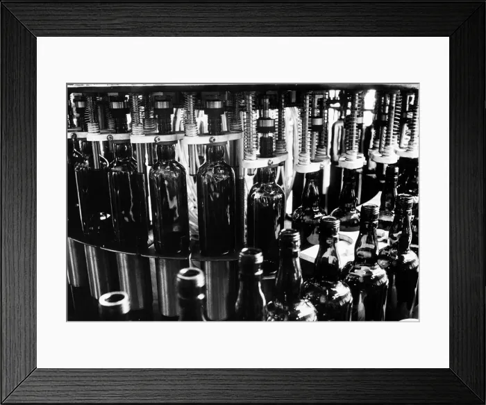 Framed Print : Bottle of Whisky on the conyevor belt at a a bottling plant 1971
