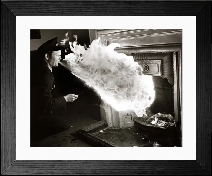 Framed Print : fire eater - man blowing flames from mouth to light logs in fireplace Framed Print : fire eater - man blowing flames from mouth to light logs in fireplace