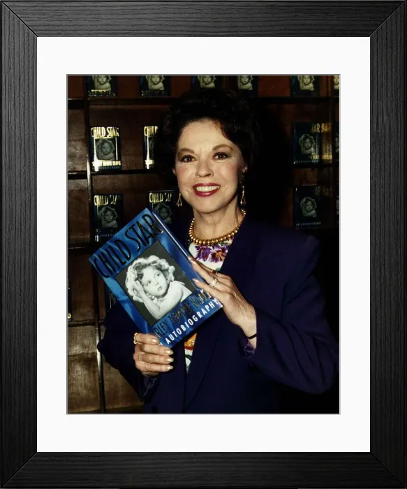 Framed Print : Shirley Temple actress holding up a copy of her book Child Star May 1989