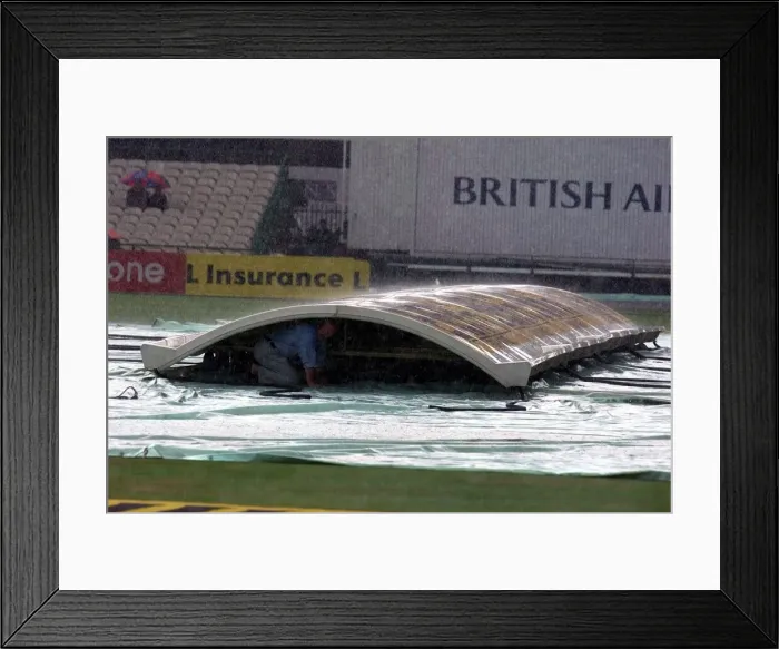 Framed Print : Groundsman Peter Marron Shelters From The Rain Under The Covers At Old Trafford Framed Print : Groundsman Peter Marron Shelters From The Rain Under The Covers At Old Trafford
