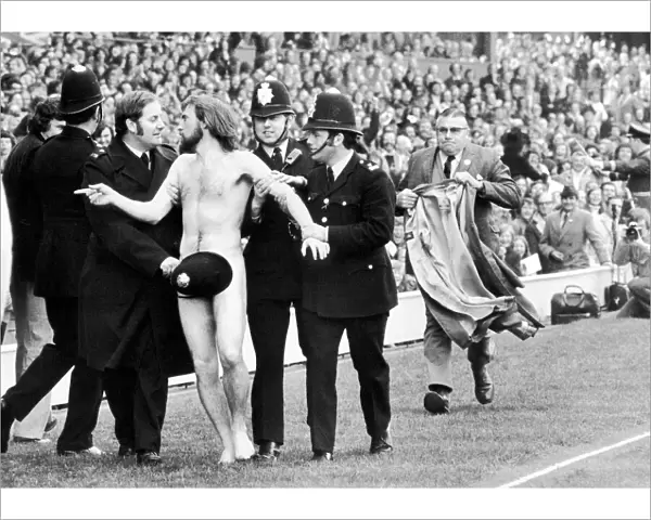 Streaker Michael O Brien sprints into the arms of awaiting policemen during half time
