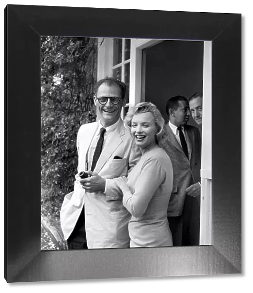 Marilyn Monroe arm in arm with husband Arthur Miller July 1956. smiling