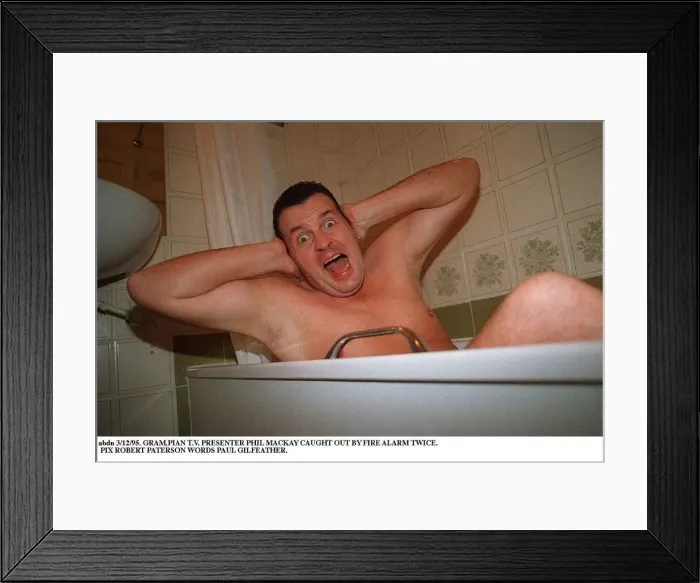 Framed Print : Phil MacKay Grampian TV Presenter in the bath hands on ears Fire Alarm story