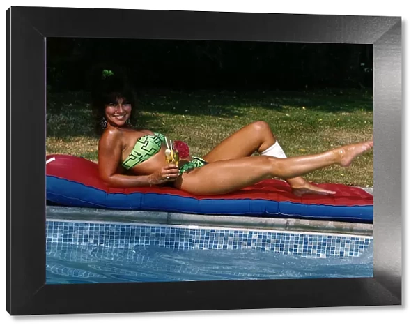 Linda Lusardi Model  /  TV Presenter laying on lilo beside pool August 1990
