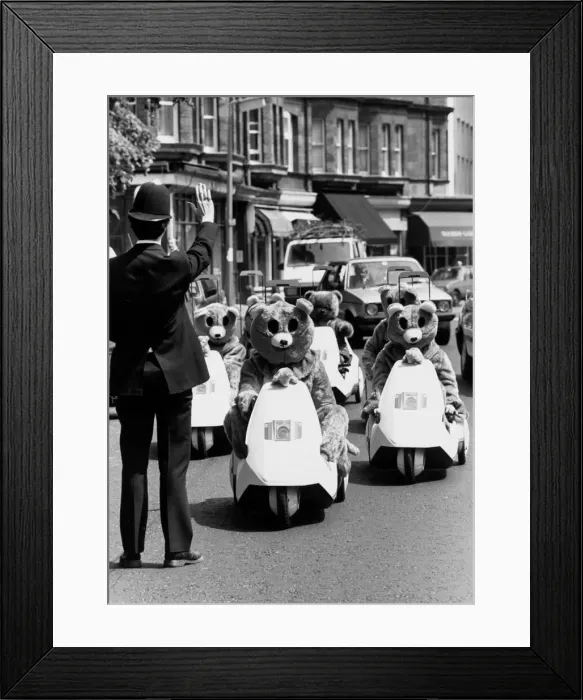 Framed Print : A policeman gestures to halt a rally of motor bears on C5s in London