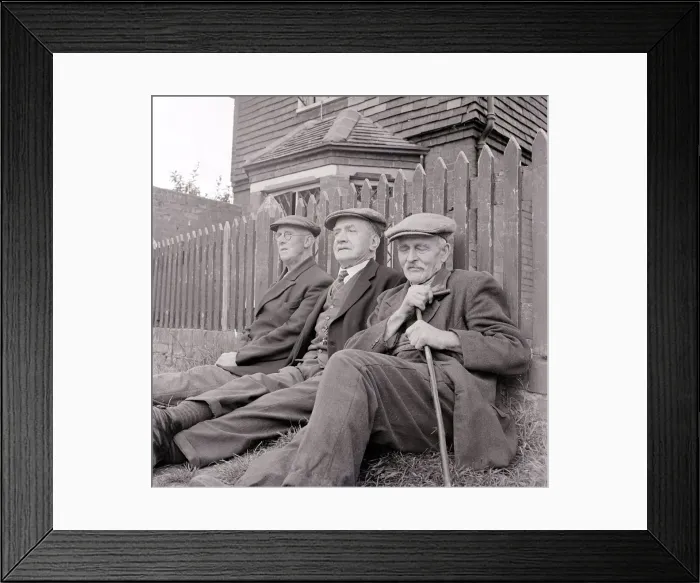 Framed Print : Three old gentlemen rest up against a wooden picket fence and watch the world go by Framed Print : Three old gentlemen rest up against a wooden picket fence and watch the world go by