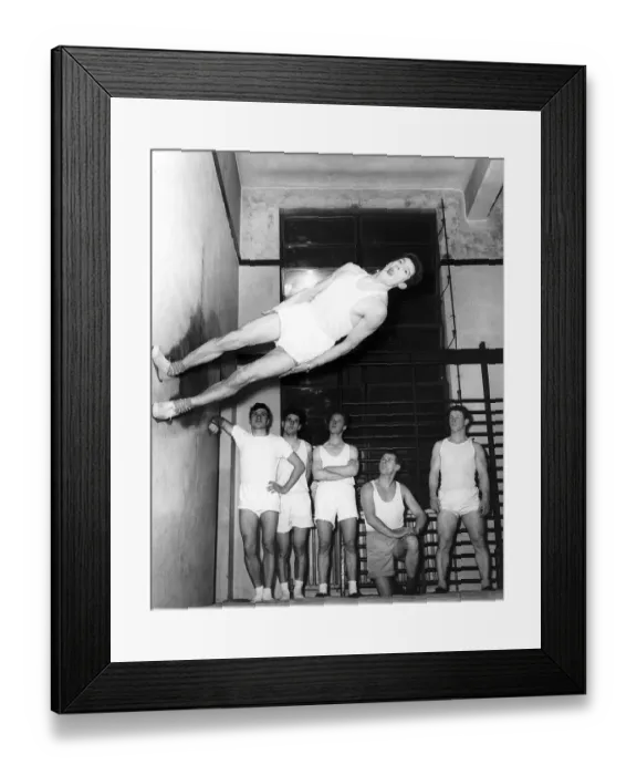 Framed Print : Gymnast Ken Popplewell walking on a wall watched by other members of the Ilford gymnastic Framed Print : Gymnast Ken Popplewell walking on a wall watched by other members of the Ilford gymnastic