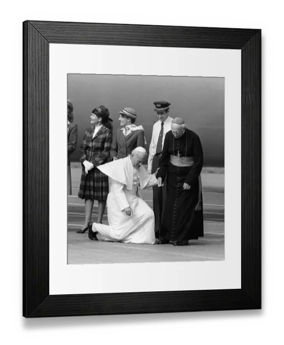 Framed Print : Pope John Paul II at Cardiff airport on his visit to Wales kneels down to kiss the ground