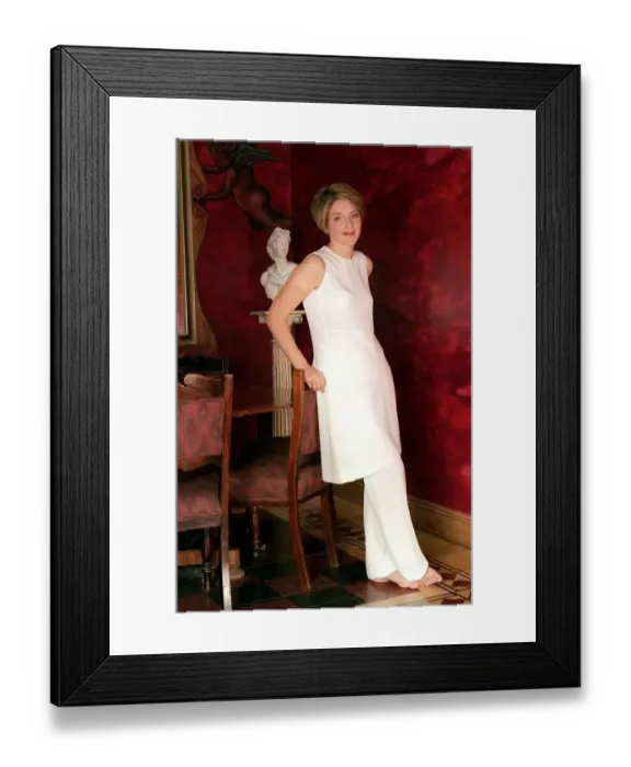 Framed Print : Kaye Adams TV presenter at home February 1999 leaning on chair wearing white dress
