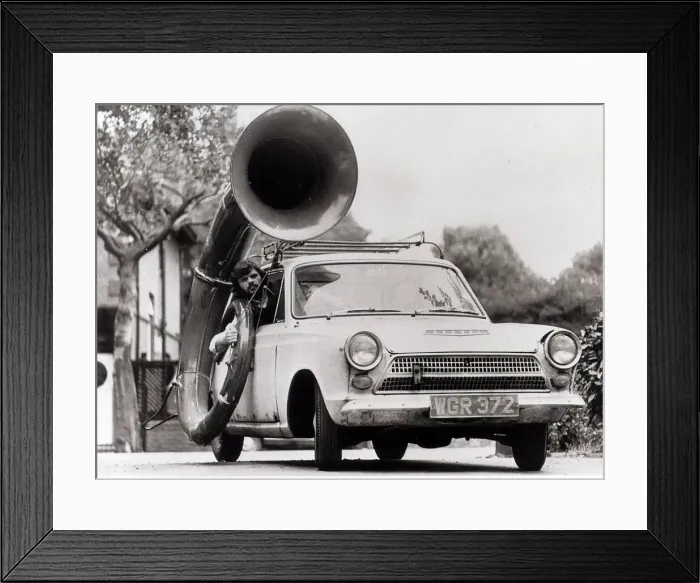 Framed Print : Ford Cortina Mk1 Car. A man drives the car with a large horn instrument strapped to