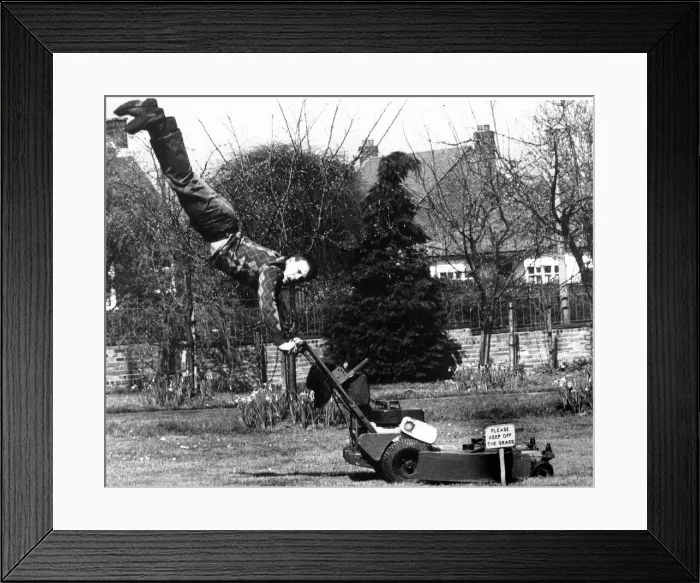 Framed Print : Man holding on to lawn mower cutting grass with sign Please Keep of the Grass
