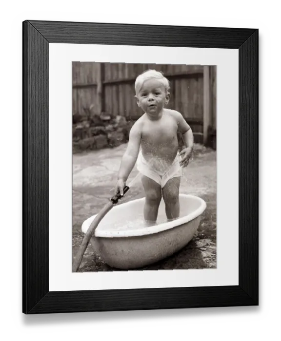 Framed Print : Boy washing in a bath tub. Circa 1950