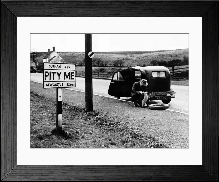 Framed Print : A Man trying to repair a punctured tyre outside the Hamlet of PITY ME in Durham county Framed Print : A Man trying to repair a punctured tyre outside the Hamlet of PITY ME in Durham county