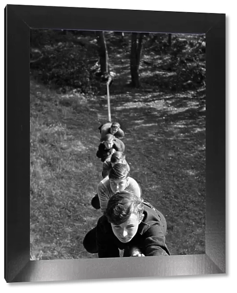 Boys climbing up a rope at the Outward Bound Sea School at Aberdovey Wales