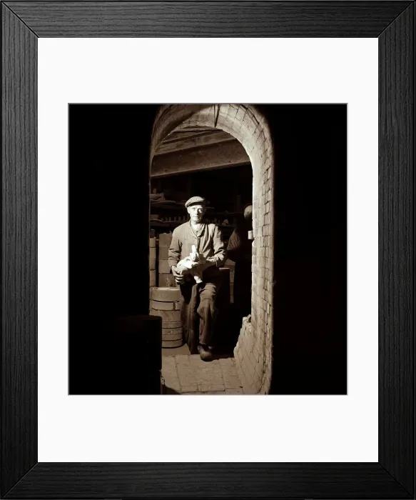 Framed Print : A warehouse worker retrieves a white elephant from the stores circa 1950s