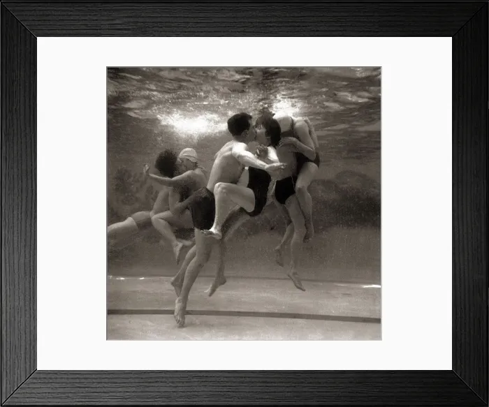 Framed Print : Couples searching for privacy beneath the waters of the swimming pool steal a shy kiss