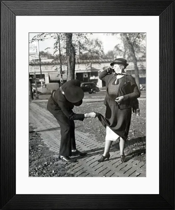 Framed Print : A traffic warden lifts the hem of a ladys dress to reveal her petticoats Framed Print : A traffic warden lifts the hem of a ladys dress to reveal her petticoats