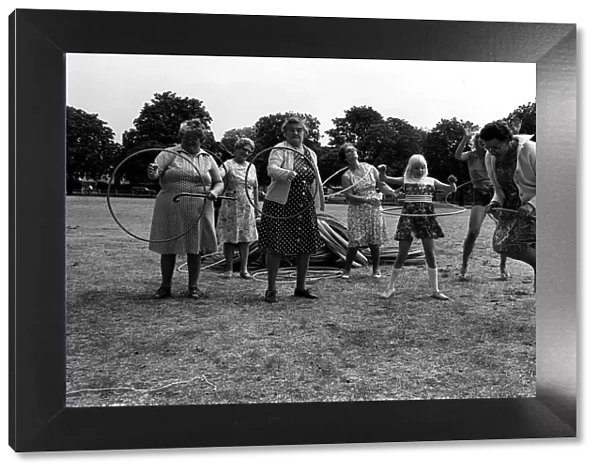 Pensioners playing with Hula Hoops in park August 1976