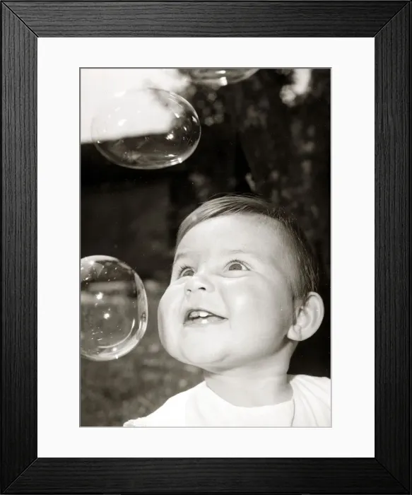 Framed Print : Little boy blowing bubbles, circa 1950