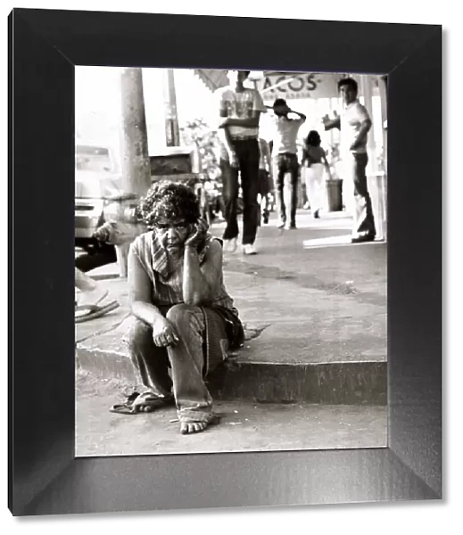 Street scene in Tijuana, Mexico - August 1977, homeless woman sitting on the pavement