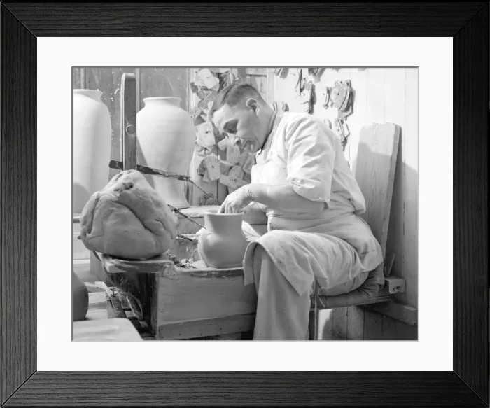 Framed Print : A potter sits at his potters wheel and throws a pot. Circa 1930 Framed Print : A potter sits at his potters wheel and throws a pot. Circa 1930