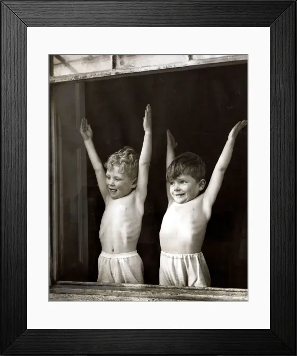 Framed Print : Two young boys doing stretching and breathing exercises in front of an open window