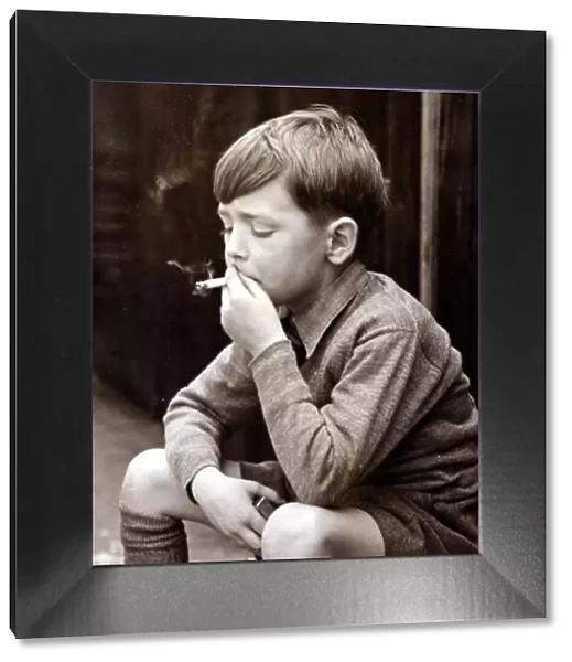 Naughty boy smoking a cigarette, circa 1950