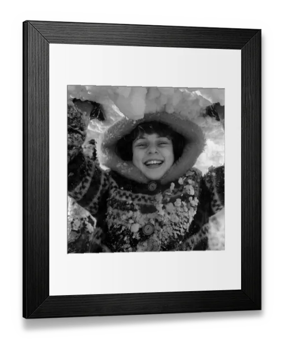 Framed Print : Children playing in the snow on Hampstead Heath on New Years Day 1962 A girl holds