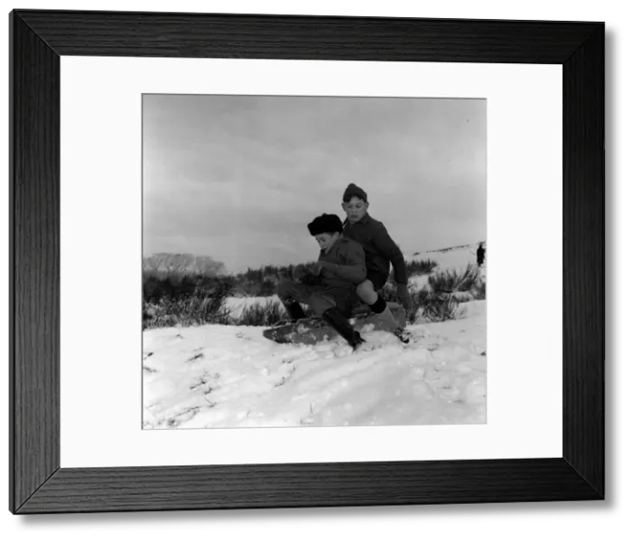 Framed Print : Two young boys riding their sledge down a snow covered hill January 1960 Framed Print : Two young boys riding their sledge down a snow covered hill January 1960