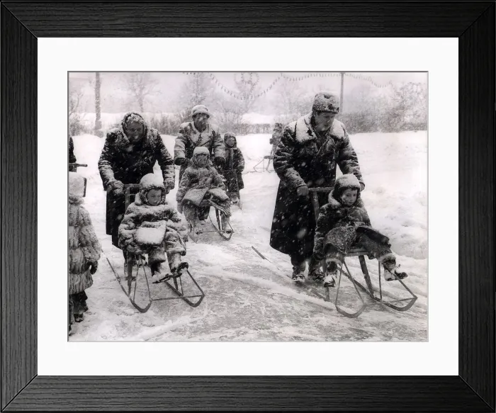Framed Print : Winter Russian style with adults pushing children in chair sledges while being well