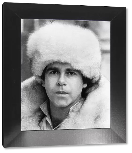 Elton John pop singer wearing a white fur hat and coat. 1978