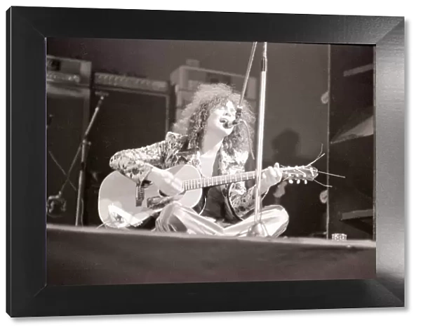 Marc Bolan in concert at th Empire Pool, Wembley. Sitting on stage cross legged