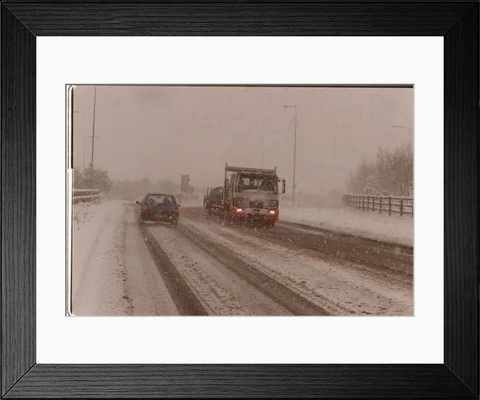 Framed Print : Traffic driving along a snow covered road in kent after Britain was hit by the Big Freeze Framed Print : Traffic driving along a snow covered road in kent after Britain was hit by the Big Freeze