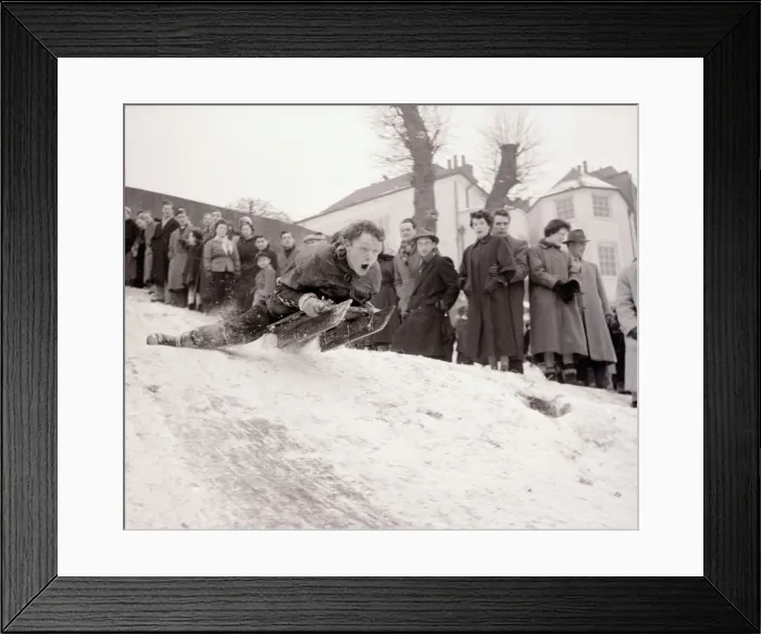 Framed Print : A boy goes flying down a snow covered hill on a sledge at Hampstead Heath February