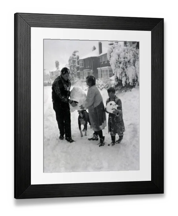 Framed Print : Children build a snowman with the help of their boxer dog in Hadley Wood Hertforshire Framed Print : Children build a snowman with the help of their boxer dog in Hadley Wood Hertforshire