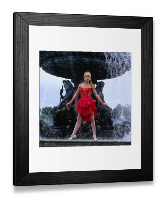 Framed Print : Carol Smillie model TV presenter wearing red dress standing ion front of a water fountain