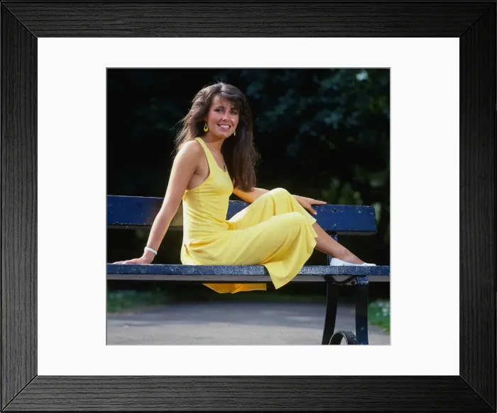Framed Print : Debbie Greenwood TV presenter July 1987 sitting on a bench wearing a yellow dress