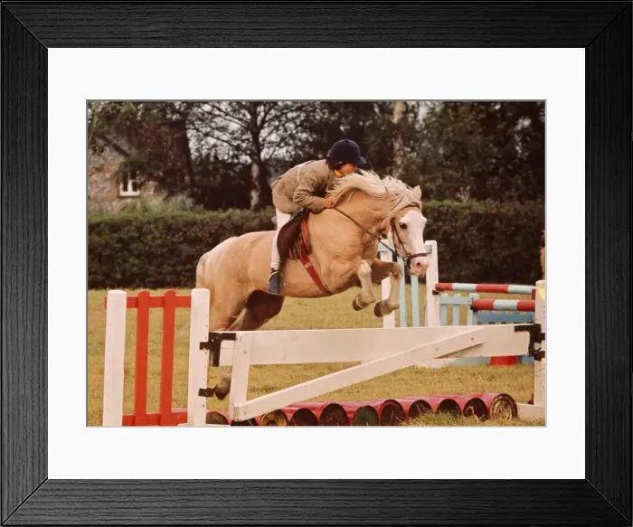 Framed Print : A girl rides hers horse over one of the jumps during Gymkhana at Luddesdown