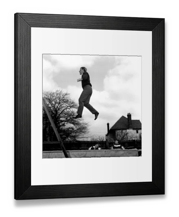 Framed Print : Racing driver Graham Hill at home with children 1968 on trampoline in his garden