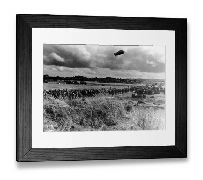 Framed Print : A barrage balloon floats overhead as British troops march towards the front line in